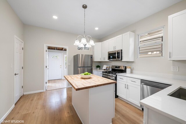 6317 W Cuyler Ave, Chicago, IL 60634 - kitchen with appliances with stainless steel finishes, butcher block countertops, light wood finished floors, white cabinetry, and recessed lighting