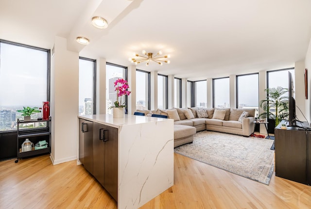 100 E Walton St Unit 38H, Chicago, IL 60611 - kitchen featuring light wood-style floors, light stone countertops, a chandelier, a wall of windows, and open floor plan