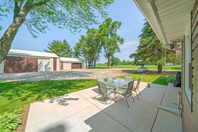 14893 Plank Rd, Sycamore, IL 60178 - view of patio with outdoor dining area, a detached garage, and an outdoor structure
