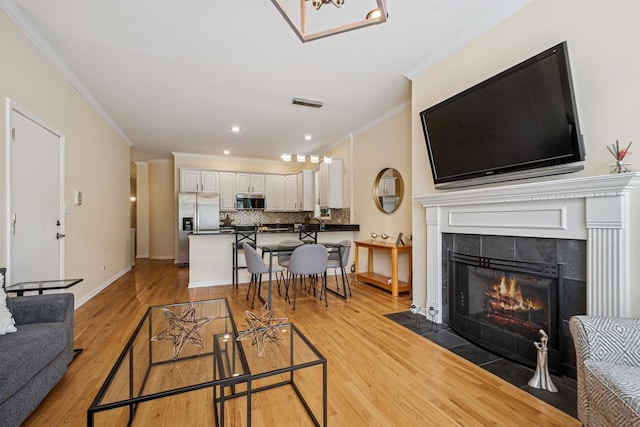 1720 W Diversey Pkwy Unit 1, Chicago, IL 60614 - living room with crown molding, light wood finished floors, a tiled fireplace, and recessed lighting