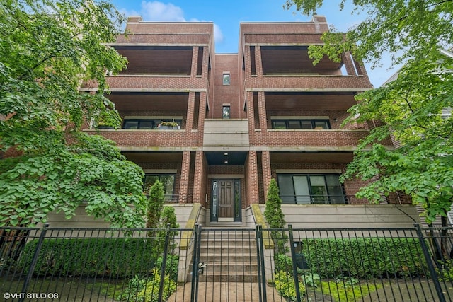 639 W Briar Pl Unit 4W, Chicago, IL 60657 - view of front of property with brick siding, a fenced front yard, and a gate