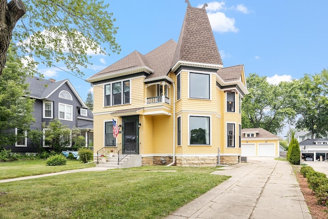 557 Garfield Ave, Aurora, IL 60506 - victorian-style house featuring a balcony, a shingled roof, a front lawn, and a detached garage