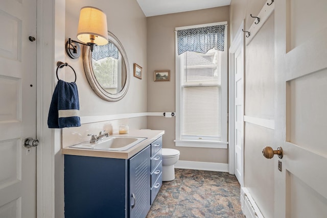 557 Garfield Ave, Aurora, IL 60506 - bathroom featuring vanity, stone finish floors, and baseboard heating