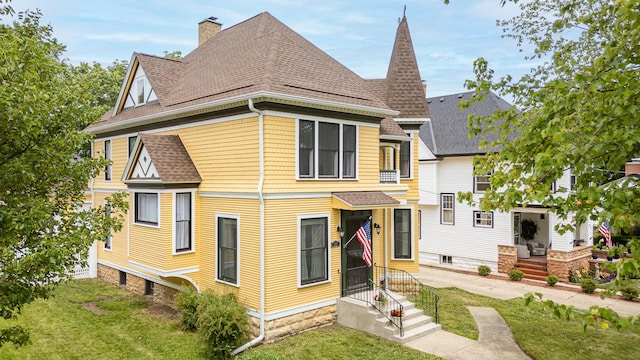 557 Garfield Ave, Aurora, IL 60506 - rear view of house featuring a shingled roof, a chimney, and a yard