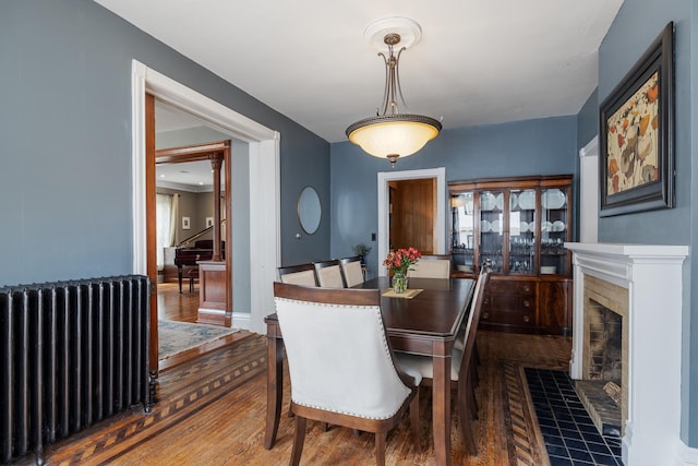 557 Garfield Ave, Aurora, IL 60506 - dining space with radiator, wood finished floors, and a fireplace