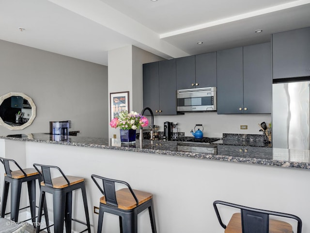 500 W Superior St Unit 1202, Chicago, IL 60654 - kitchen featuring stainless steel appliances, a kitchen breakfast bar, dark stone counters, recessed lighting, and a peninsula