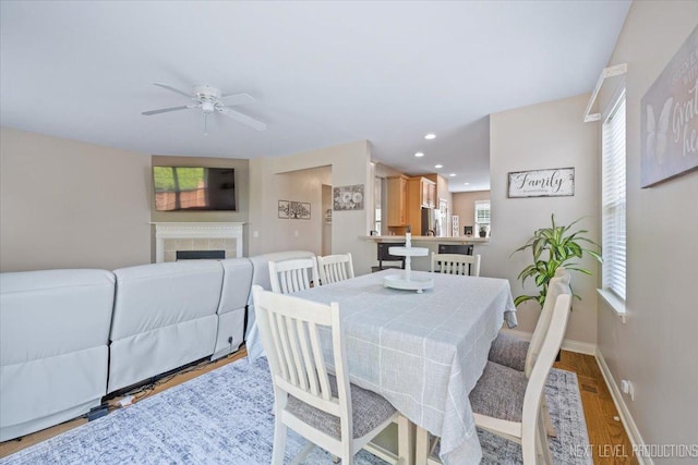725 Bohannon Cir, Oswego, IL 60543 - dining area featuring a ceiling fan, wood finished floors, a tile fireplace, and recessed lighting