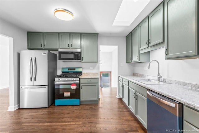 8826 Willow Rd, Hickory Hills, IL 60457 - kitchen featuring stainless steel appliances, green cabinets, a skylight, light countertops, and dark wood-style flooring
