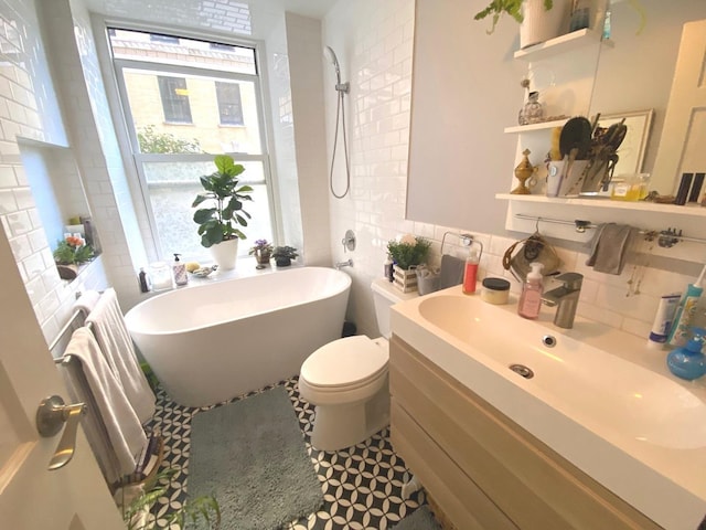 559 W Surf St Unit 101, Chicago, IL 60657 - bathroom featuring a freestanding bath, backsplash, vanity, radiator heating unit, and tile walls