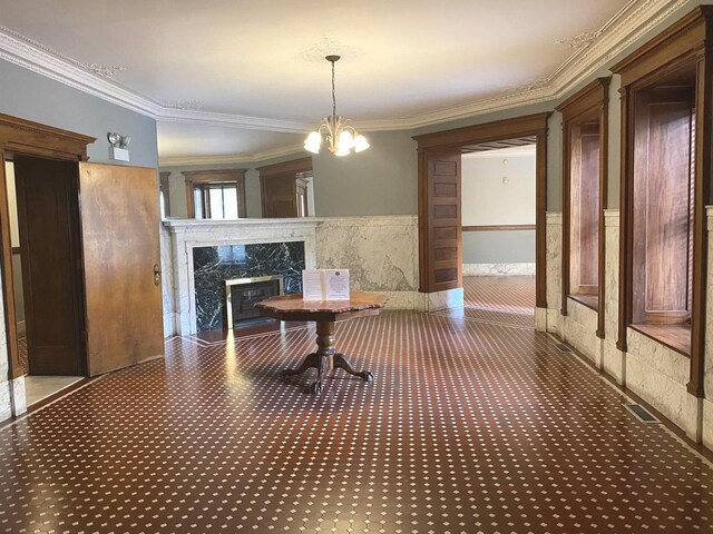 559 W Surf St Unit 101, Chicago, IL 60657 - carpeted dining area featuring ornamental molding, a premium fireplace, and a chandelier