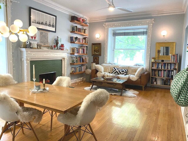 559 W Surf St Unit 101, Chicago, IL 60657 - dining room with crown molding, wood finished floors, a fireplace, and a ceiling fan