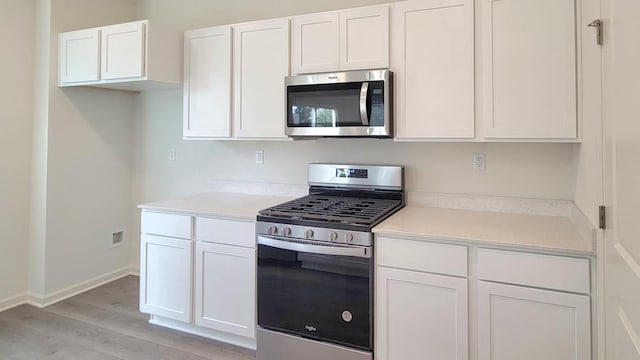 11300 Wildridge Ln, Huntley, IL 60142 - kitchen featuring appliances with stainless steel finishes, white cabinetry, and light wood-type flooring