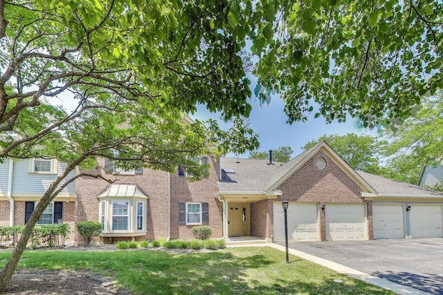 2406 Mallow Ct Unit V2, Schaumburg, IL 60194 - view of front of house featuring asphalt driveway, a garage, brick siding, a front lawn, and a shingled roof