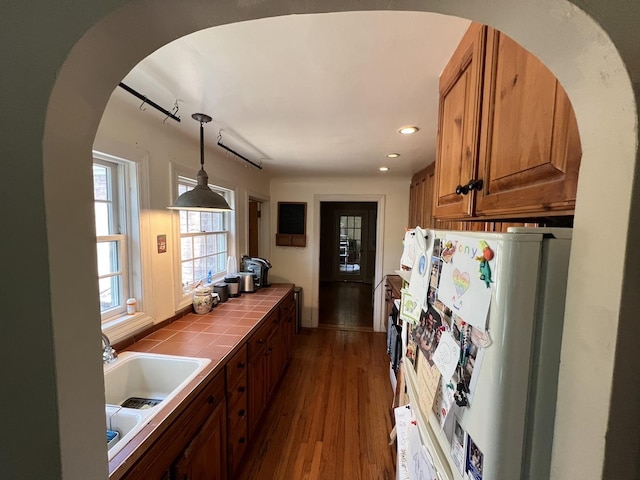 500 N Grant St, Westmont, IL 60559 - kitchen with tile countertops, freestanding refrigerator, brown cabinets, arched walkways, and dark wood-type flooring