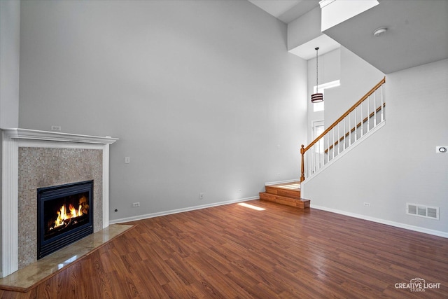 24825 W Gates Ct, Plainfield, IL 60585 - unfurnished living room featuring a towering ceiling, wood finished floors, stairway, and a fireplace