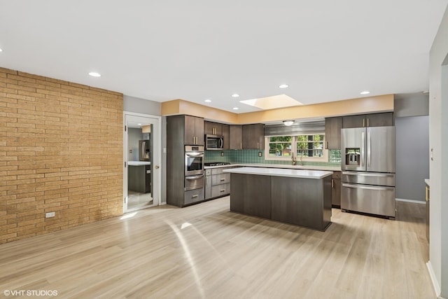 3071 Plum Island Dr, Northbrook, IL 60062 - kitchen with stainless steel appliances, dark brown cabinetry, light countertops, light wood-style flooring, and a warming drawer