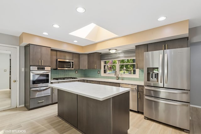 3071 Plum Island Dr, Northbrook, IL 60062 - kitchen featuring stainless steel appliances, a skylight, a warming drawer, dark brown cabinets, and light countertops