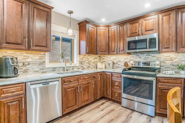 2241 S 17th Ave, North Riverside, IL 60546 - kitchen featuring appliances with stainless steel finishes, light wood-style floors, hanging light fixtures, light stone counters, and tasteful backsplash