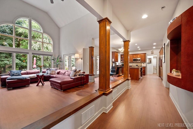 7N107 Hastings Dr, Saint Charles, IL 60175 - living room featuring decorative columns, light wood-style flooring, ceiling fan, recessed lighting, and high vaulted ceiling