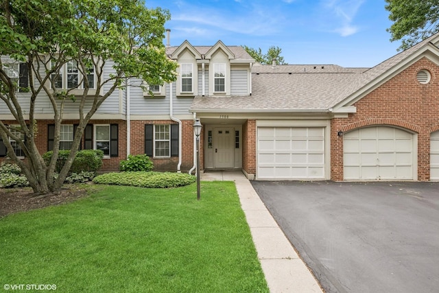 1508 Seville Ct Unit D2, Wheeling, IL 60090 - view of property with brick siding, a front yard, a shingled roof, a garage, and driveway