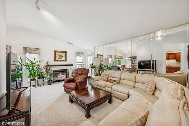 1508 Seville Ct Unit D2, Wheeling, IL 60090 - living room featuring lofted ceiling, track lighting, a glass covered fireplace, and carpet flooring