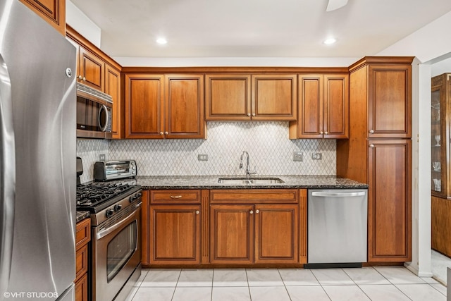 1508 Seville Ct Unit D2, Wheeling, IL 60090 - kitchen with stainless steel appliances, brown cabinetry, dark stone countertops, backsplash, and light tile patterned flooring