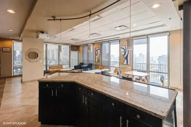 2 E Erie St Unit 3106, Chicago, IL 60611 - kitchen featuring dark cabinetry, light tile patterned floors, open floor plan, and light stone counters