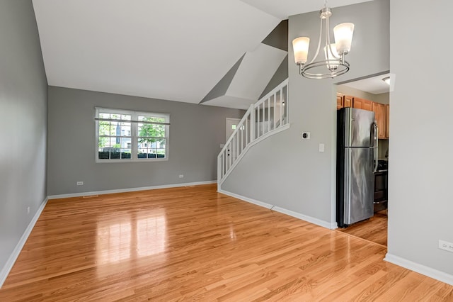 1400 Carleton Ave, Naperville, IL 60565 - unfurnished living room featuring a chandelier, vaulted ceiling, light wood finished floors, and stairway