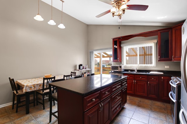 21023 Siegel Dr, Crest Hill, IL 60403 - kitchen featuring dark brown cabinets, lofted ceiling, dark countertops, range with two ovens, and a ceiling fan