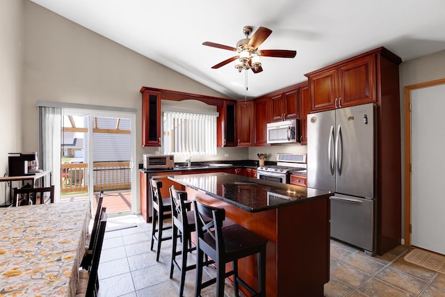 21023 Siegel Dr, Crest Hill, IL 60403 - kitchen featuring appliances with stainless steel finishes, lofted ceiling, ceiling fan, dark stone countertops, and a kitchen bar