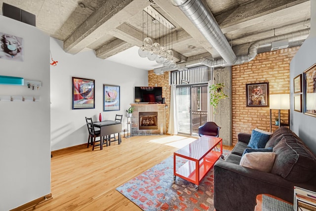 6135 N Broadway St Unit 303, Chicago, IL 60660 - living area featuring wood finished floors, a fireplace, and brick wall