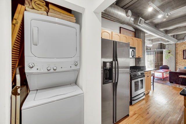 6135 N Broadway St Unit 303, Chicago, IL 60660 - laundry area featuring stacked washing machine and dryer and light wood finished floors