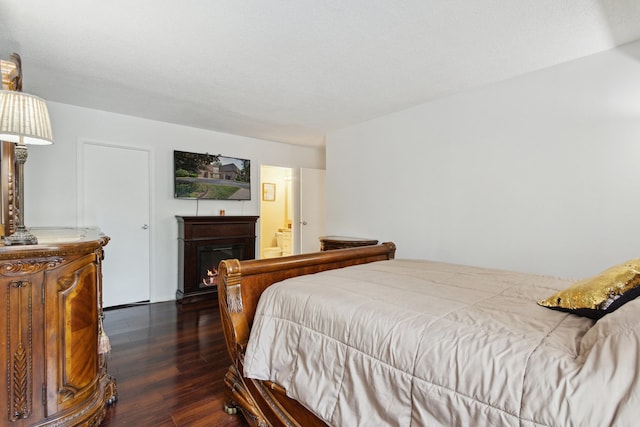 907 S Williams St Unit 206, Westmont, IL 60559 - bedroom with dark wood-type flooring, a lit fireplace, and connected bathroom