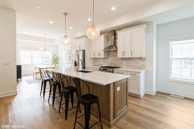 1 N Beverly Ln, Arlington Heights, IL 60004 - kitchen with wall chimney exhaust hood, appliances with stainless steel finishes, a kitchen bar, a kitchen island with sink, and decorative backsplash