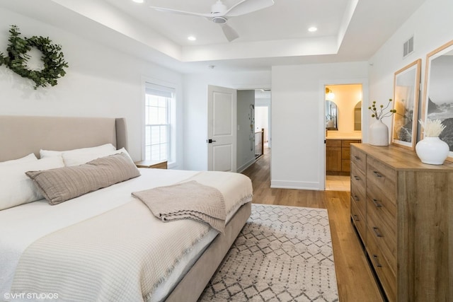 1 N Beverly Ln, Arlington Heights, IL 60004 - bedroom with light wood-style flooring, a tray ceiling, recessed lighting, connected bathroom, and a ceiling fan