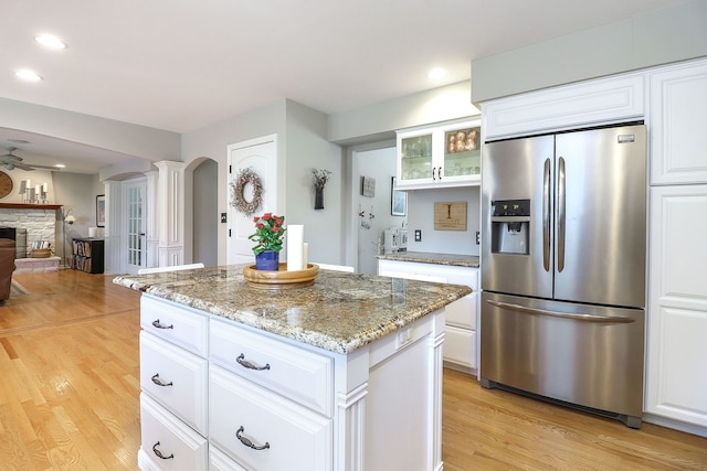 1549 Preston Rd, Naperville, IL 60563 - kitchen with stainless steel fridge with ice dispenser, arched walkways, light wood finished floors, light stone countertops, and a center island