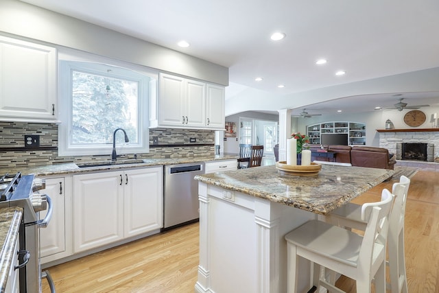 1549 Preston Rd, Naperville, IL 60563 - kitchen with appliances with stainless steel finishes, a ceiling fan, ornate columns, light wood finished floors, and light stone counters