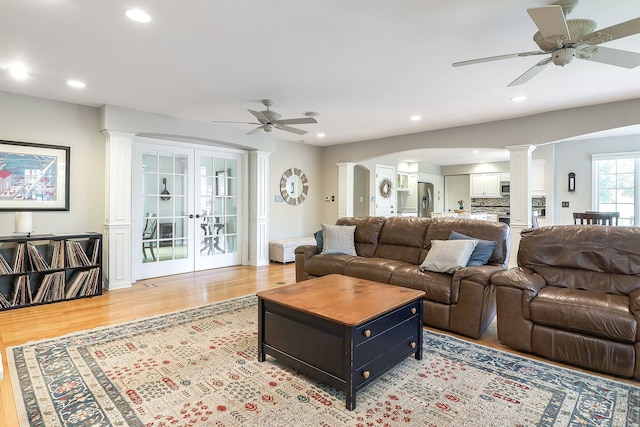 1549 Preston Rd, Naperville, IL 60563 - living room with ornate columns, ceiling fan, light wood-style floors, french doors, and arched walkways