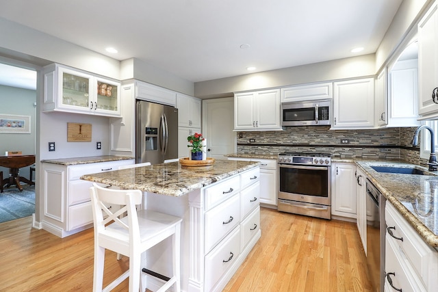 1549 Preston Rd, Naperville, IL 60563 - kitchen featuring appliances with stainless steel finishes, light wood-type flooring, a kitchen island, a breakfast bar, and recessed lighting