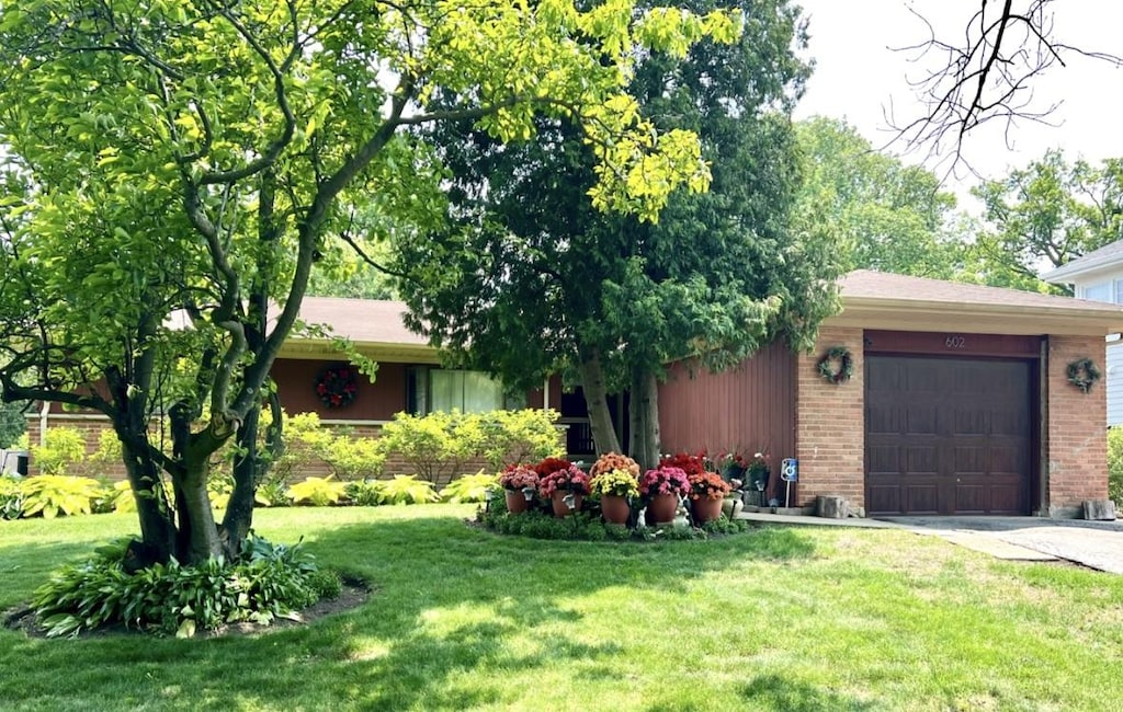 602 Old Elm Rd, Highland Park, IL 60035 - view of front of house with an attached garage, brick siding, a front lawn, and driveway