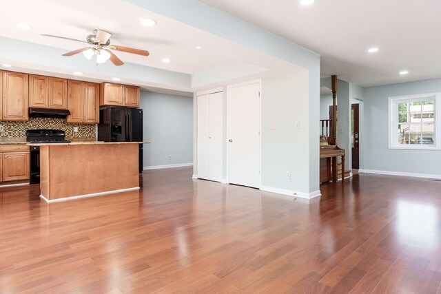 5087 Wilderness Trl, Rockford, IL 61114 - kitchen featuring gas range, under cabinet range hood, open floor plan, decorative backsplash, and a ceiling fan