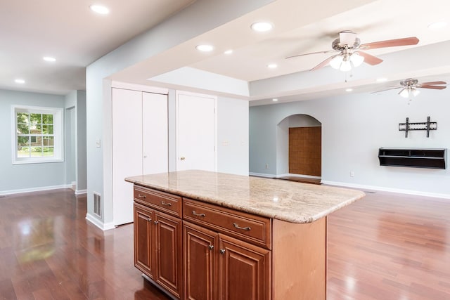 5087 Wilderness Trl, Rockford, IL 61114 - kitchen with wood finished floors, arched walkways, ceiling fan, recessed lighting, and light stone counters