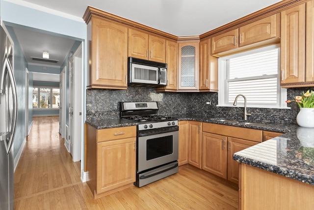 4567 N Merrimac Ave, Chicago, IL 60630 - kitchen featuring appliances with stainless steel finishes, light wood finished floors, and dark stone countertops