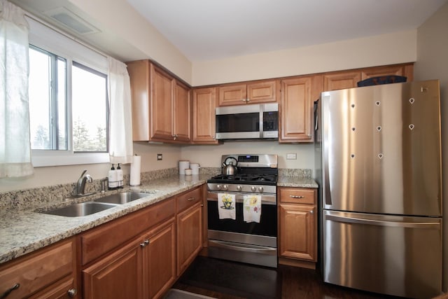 107 65th Lake Dr Unit 202, Westmont, IL 60559 - kitchen with stainless steel appliances, brown cabinetry, light stone countertops, and dark wood finished floors