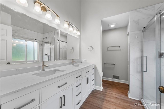 6 Ennis Ct, Cary, IL 60013 - bathroom with double vanity, a shower stall, and wood finished floors