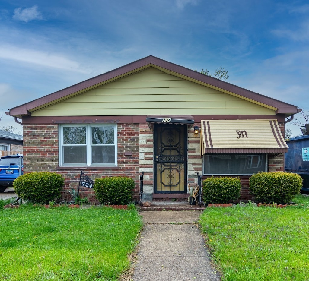 734 E 155th Pl, Phoenix, IL 60426 - bungalow-style house with a front lawn and brick siding