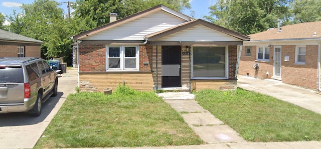734 E 155th Ct, Phoenix, IL 60426 - bungalow-style home with brick siding, a chimney, and a front lawn