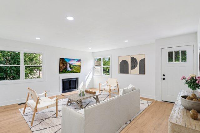 5216 Arlington Cir, Hanover Park, IL 60133 - living area featuring light wood finished floors, a fireplace, and recessed lighting