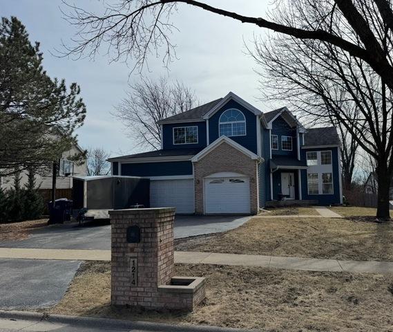 1214 Vista Dr, Gurnee, IL 60031 - view of front of house featuring an attached garage, asphalt driveway, and brick siding