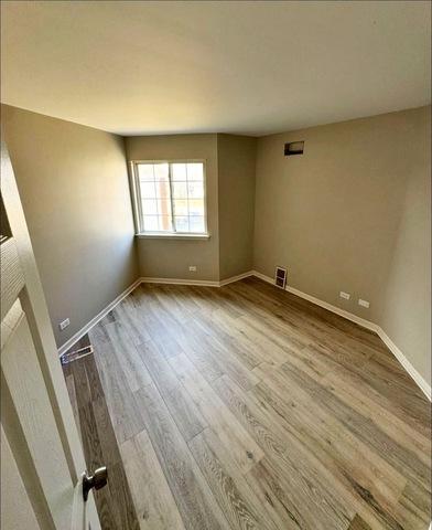 1214 Vista Dr, Gurnee, IL 60031 - spare room featuring wood finished floors and baseboards
